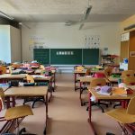 A classroom filled with lots of desks and chairs